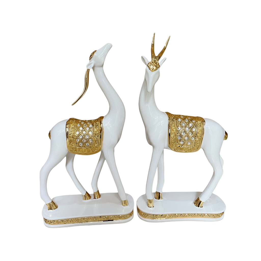 Decorative statues of white deer with gold accents on a white background