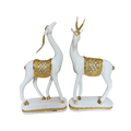Decorative statues of white deer with gold accents on a white background