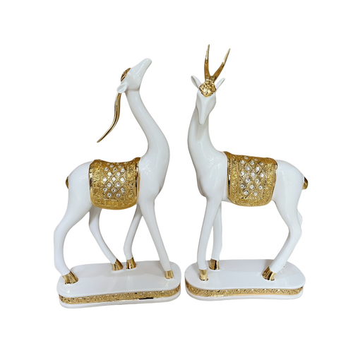 Decorative statues of white deer with gold accents on a white background